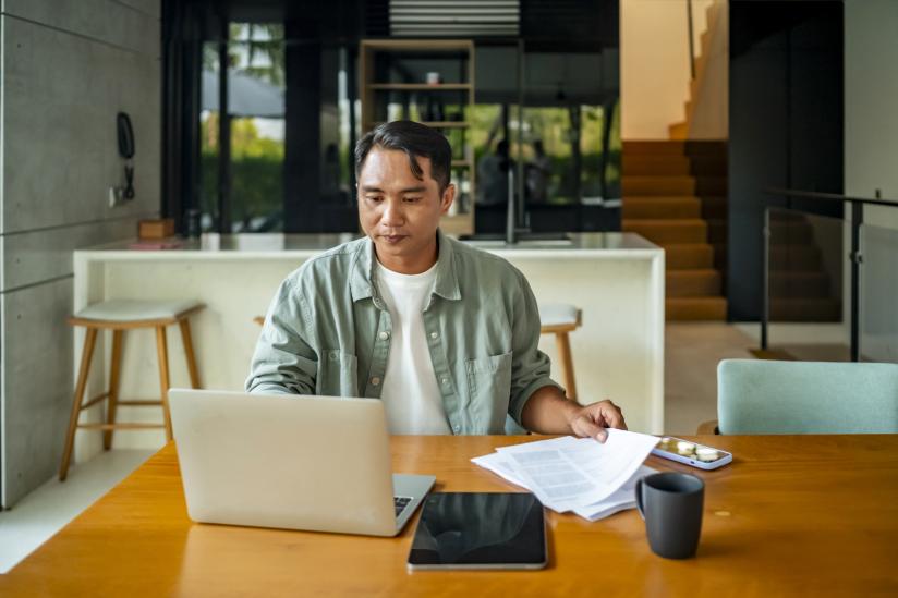 Man with laptop and papers working