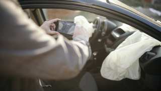 Car insurance agent at work investigating a crashed car